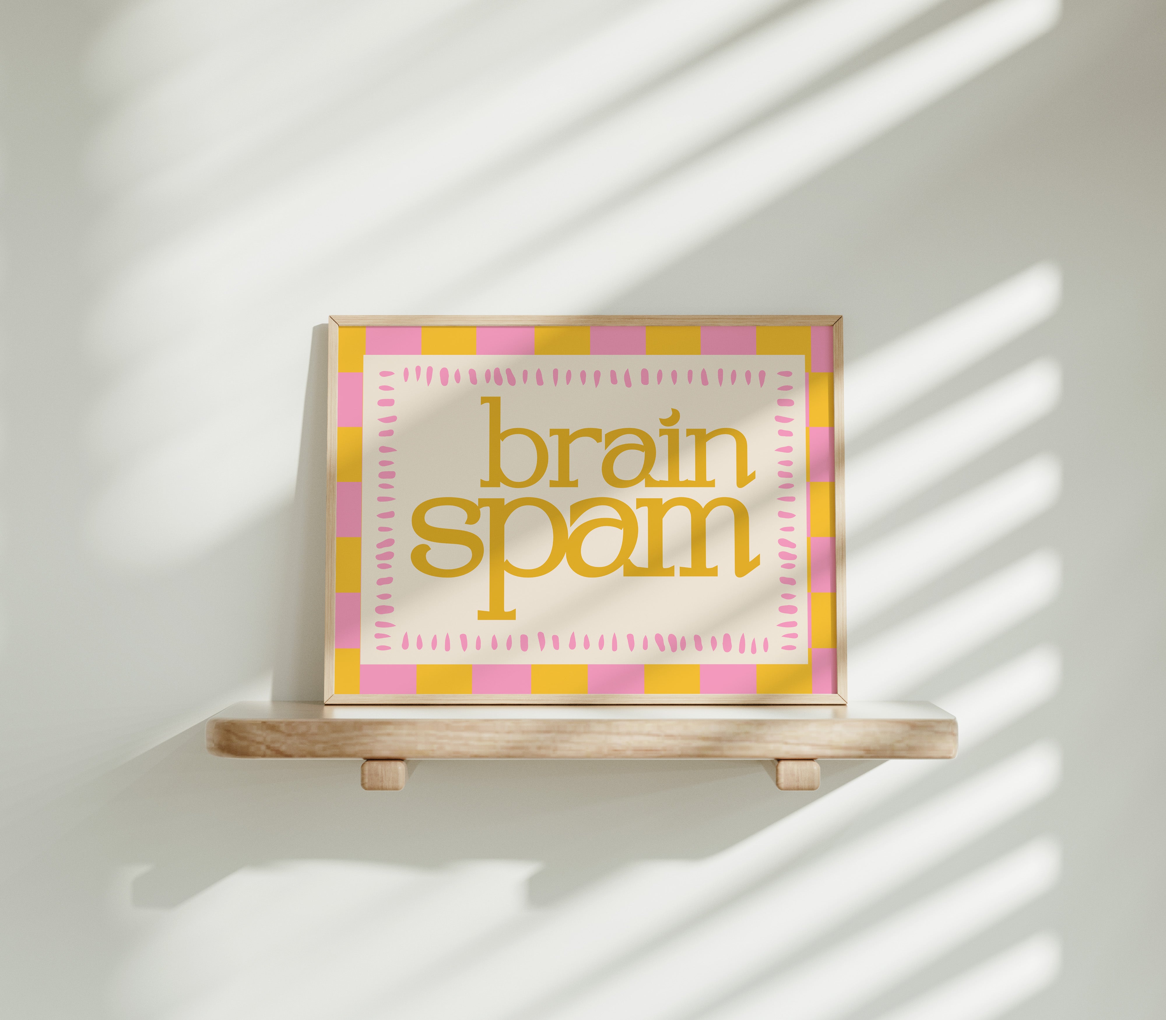 Brain Spam horizontal 24x36 mental health wall art poster displayed on a wooden shelf against a sunlit white wall