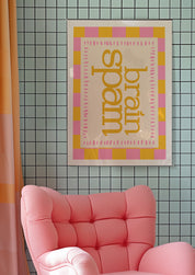 Brain Spam 24x36 mental health wall art poster framed above a pink armchair on a tiled wall