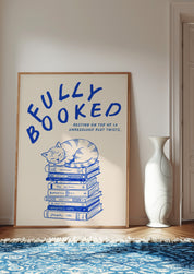 Fully Booked 24x36 bookish wall art poster leaning in a bright room on a blue patterned rug