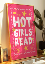 Hot Girls Read 24x36 bookish wall art poster leaning against a wall beside a potted plant