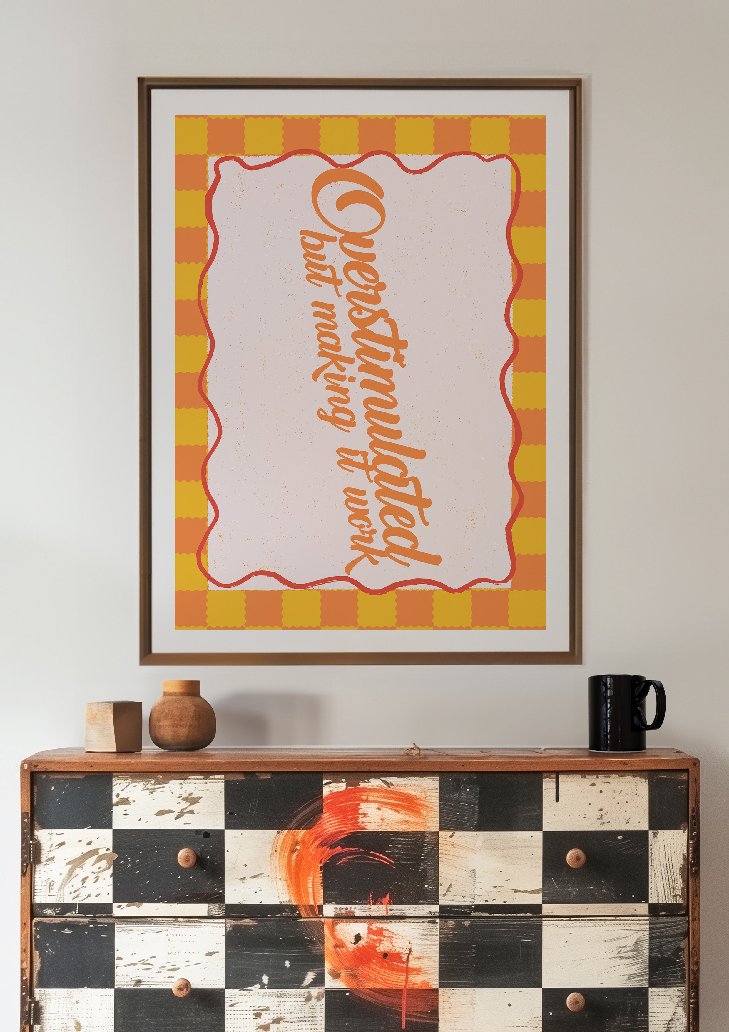 Overstimulated but Making It Work 24x36 mental health wall art poster framed above a black and white checkered dresser