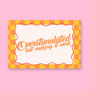 Overstimulated but Making It Work 24x36 mental health wall art poster on a pink background