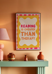 Reading Is Cheaper Than Therapy 24x36 bookish wall art poster framed above a mint green console in a peach room