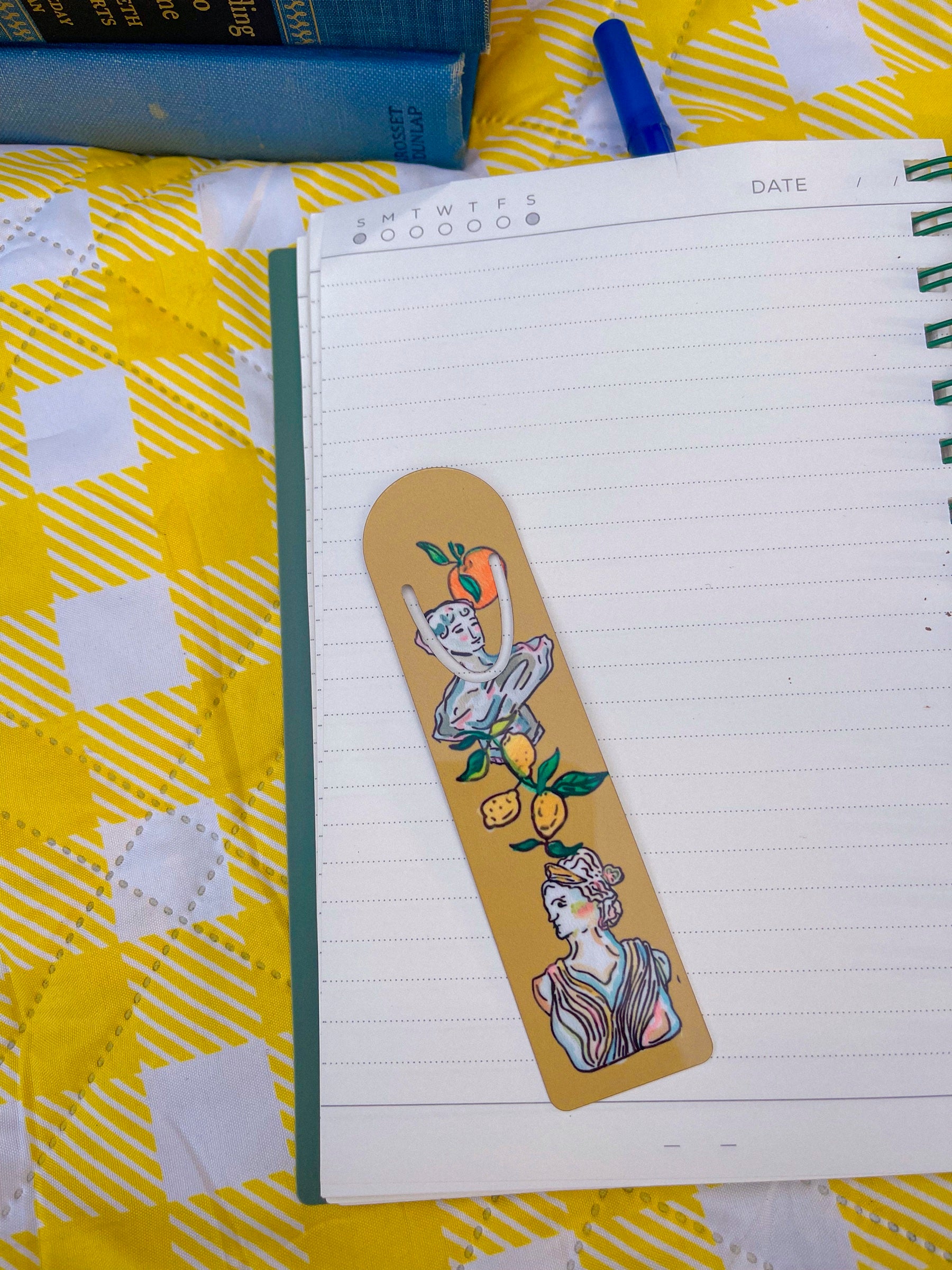 Art Deco Citrus metal bookmark on a notebook on a yellow gingham blanket