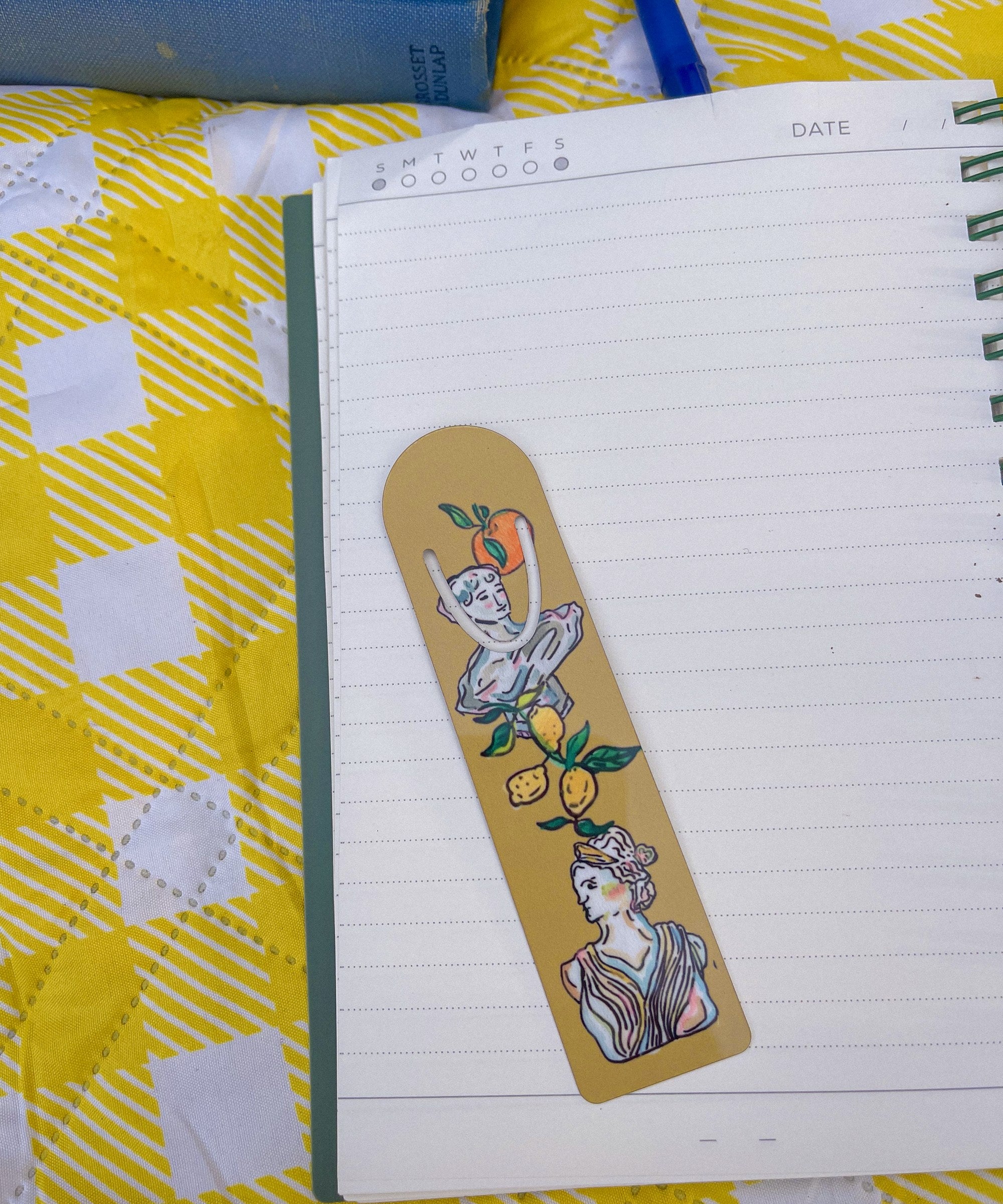 Art Deco Citrus metal bookmark on a notebook on a yellow gingham blanket