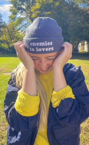 Woman wearing the navy Enemies to Lovers embroidered fisherman beanie