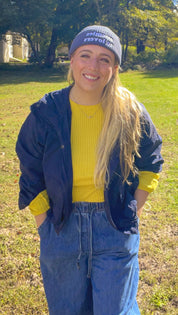 Enemies to Lovers fisherman beanie styled with a navy jacket and yellow sweater