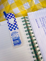 Fully Booked cat metal bookmark on a handwritten notebook page