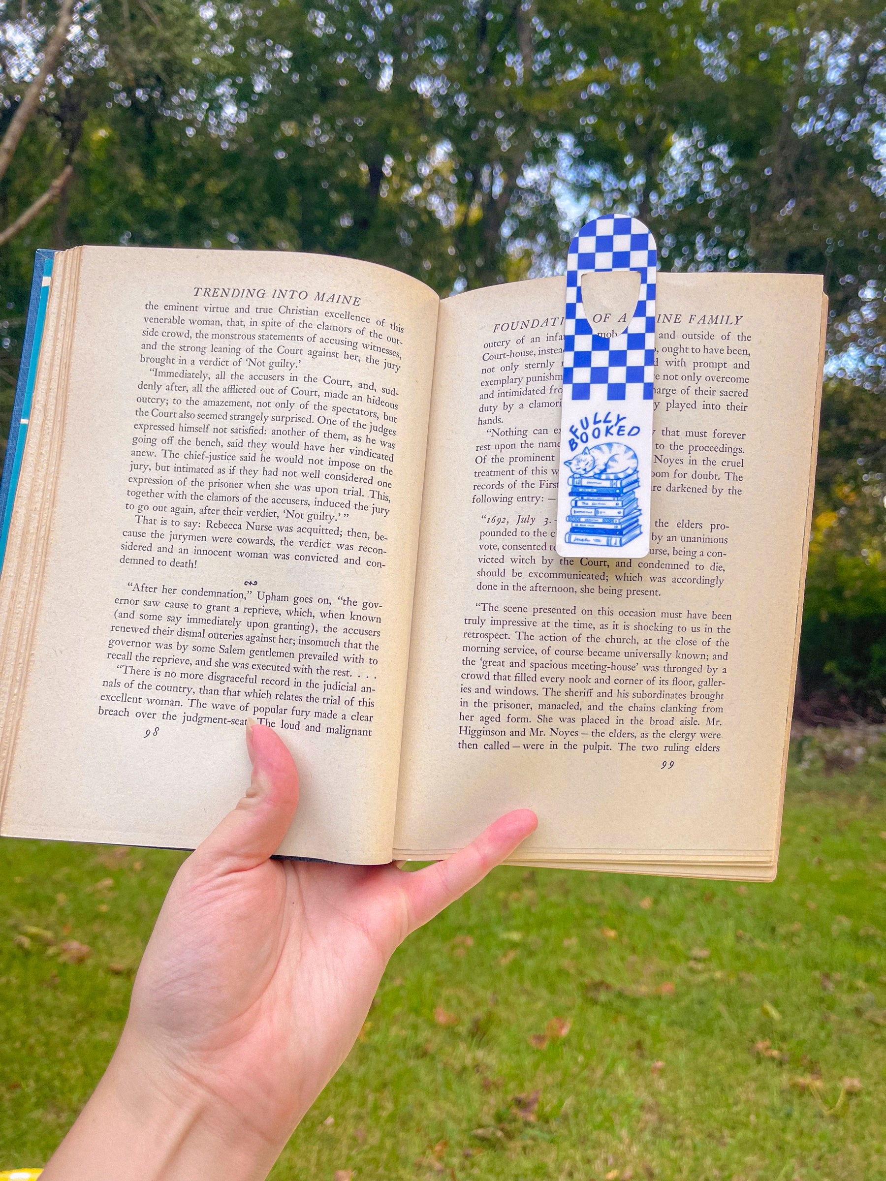 Fully Booked blue checkerboard metal bookmark in an open book outdoors