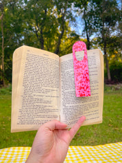 Pink Striped Lobster metal bookmark clipped in an open book outdoors