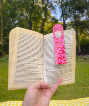 Pink Striped Lobster metal bookmark clipped in an open book outdoors