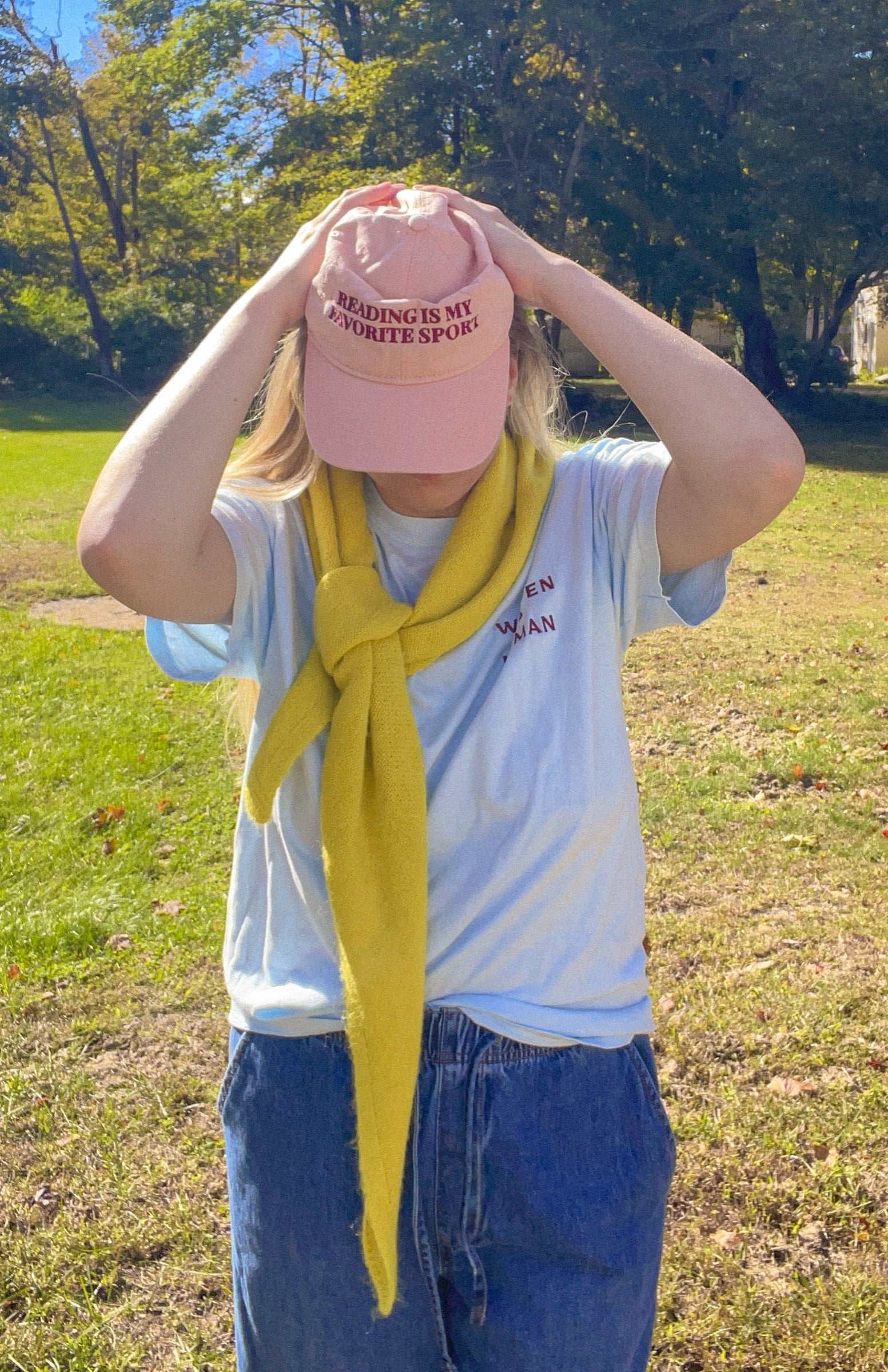 Woman adjusting the pink Reading Is My Favorite Sport coastal washed cap