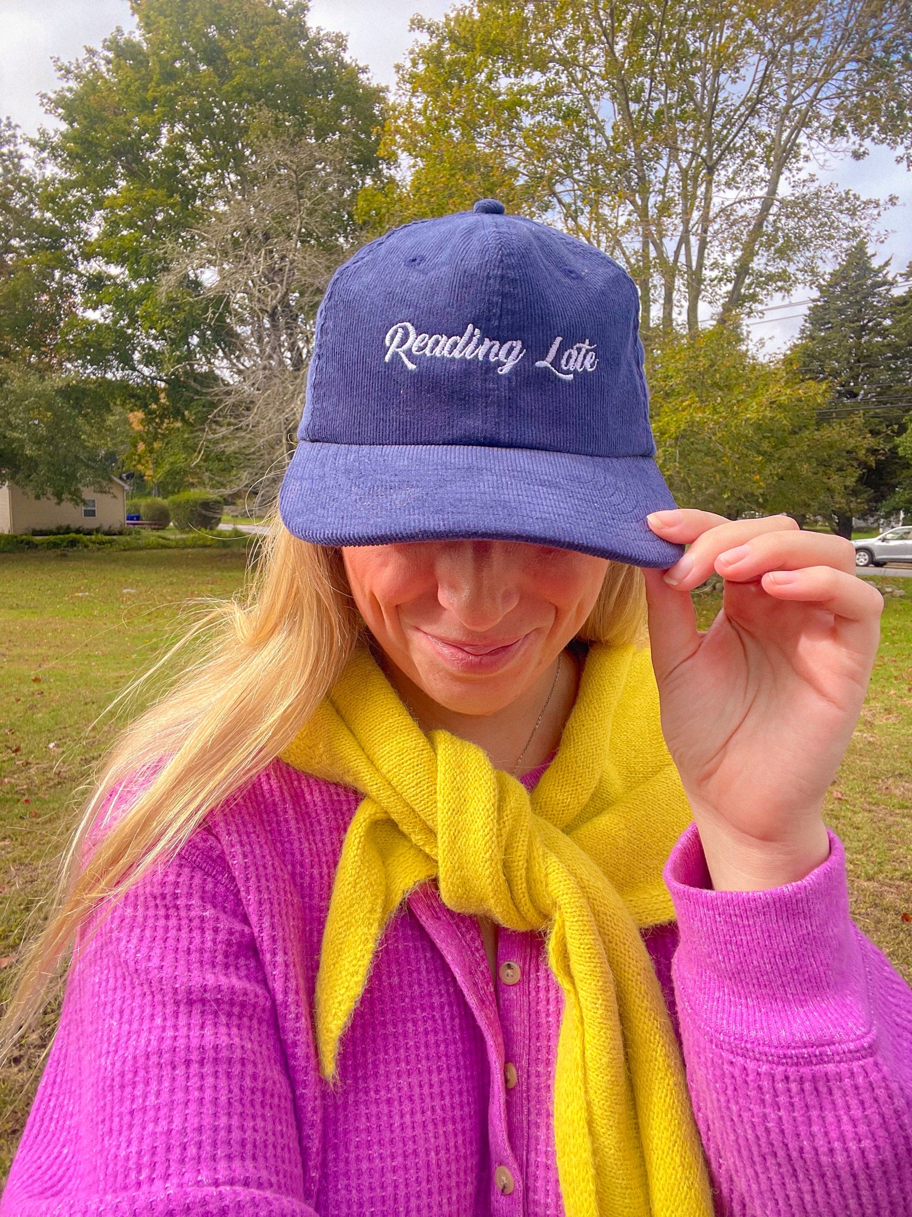 Sarah tipping a navy Reading Late embroidered corduroy hat
