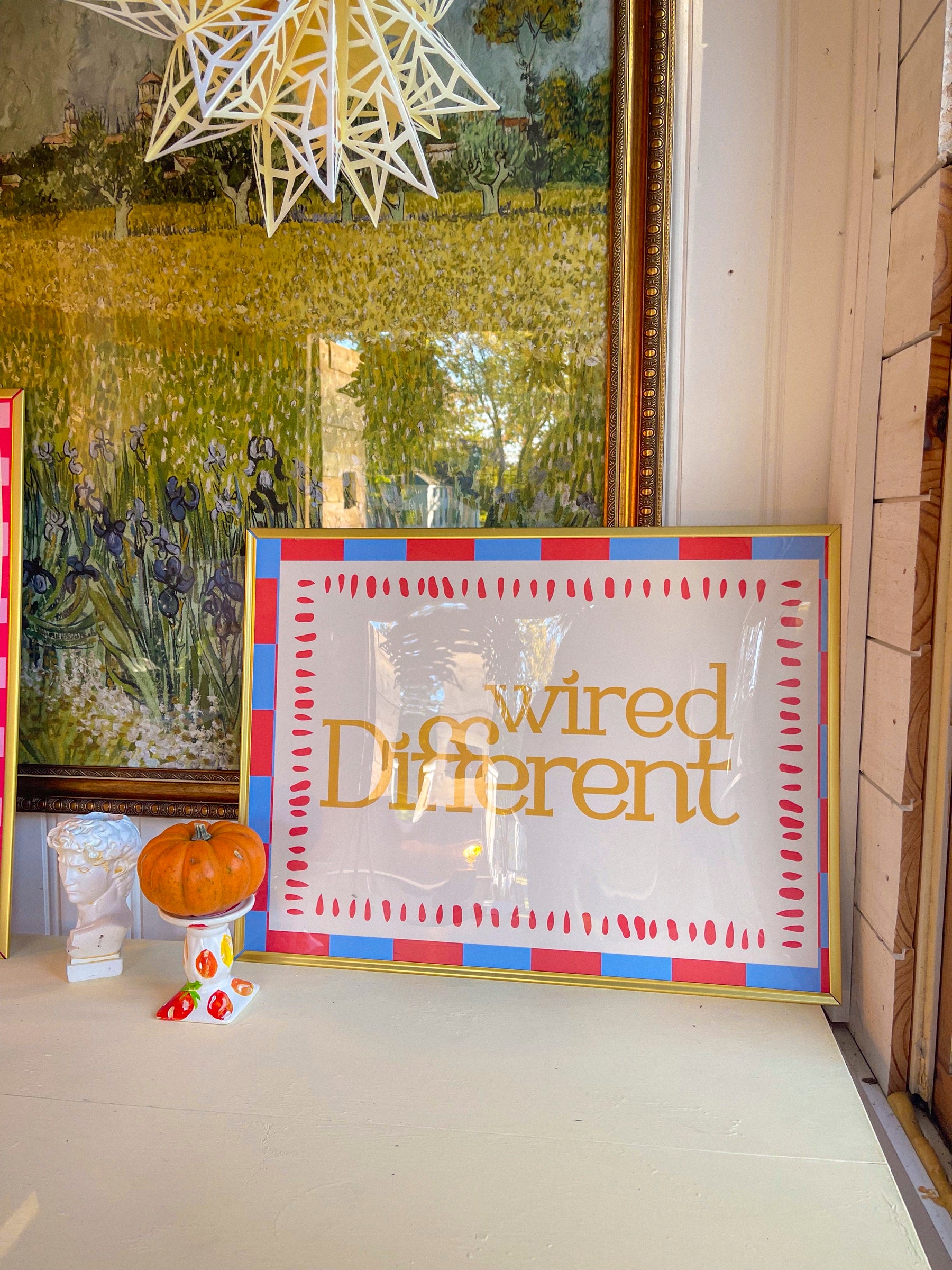 Wired Different art print in a red and blue painted frame in Sarah's studio window