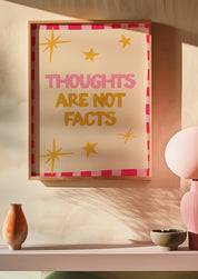 Thoughts Are Not Facts 24x36 mental health wall art poster framed on a warm blush wall above a pink shelf