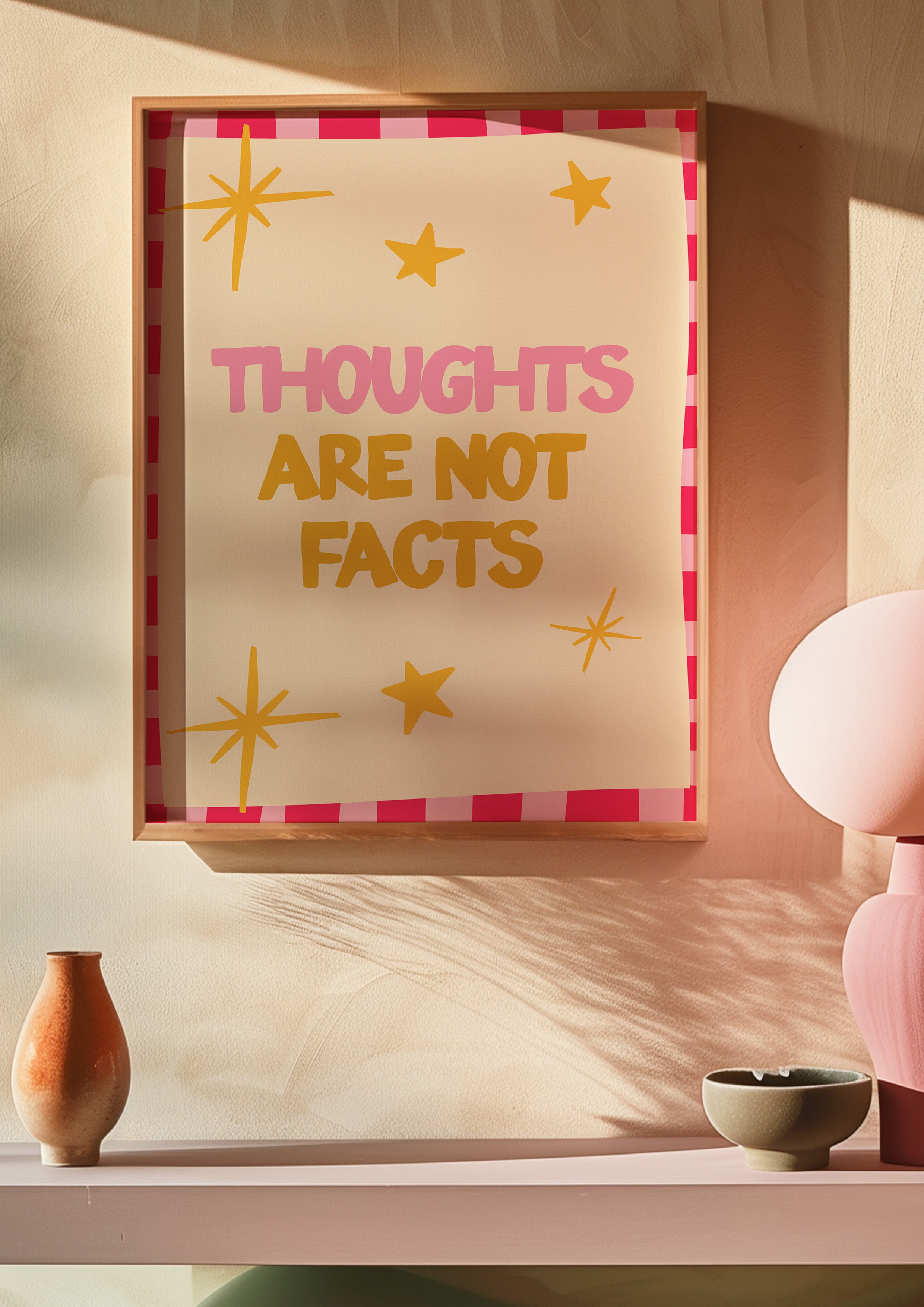 Thoughts Are Not Facts 24x36 mental health wall art poster framed on a warm blush wall above a pink shelf