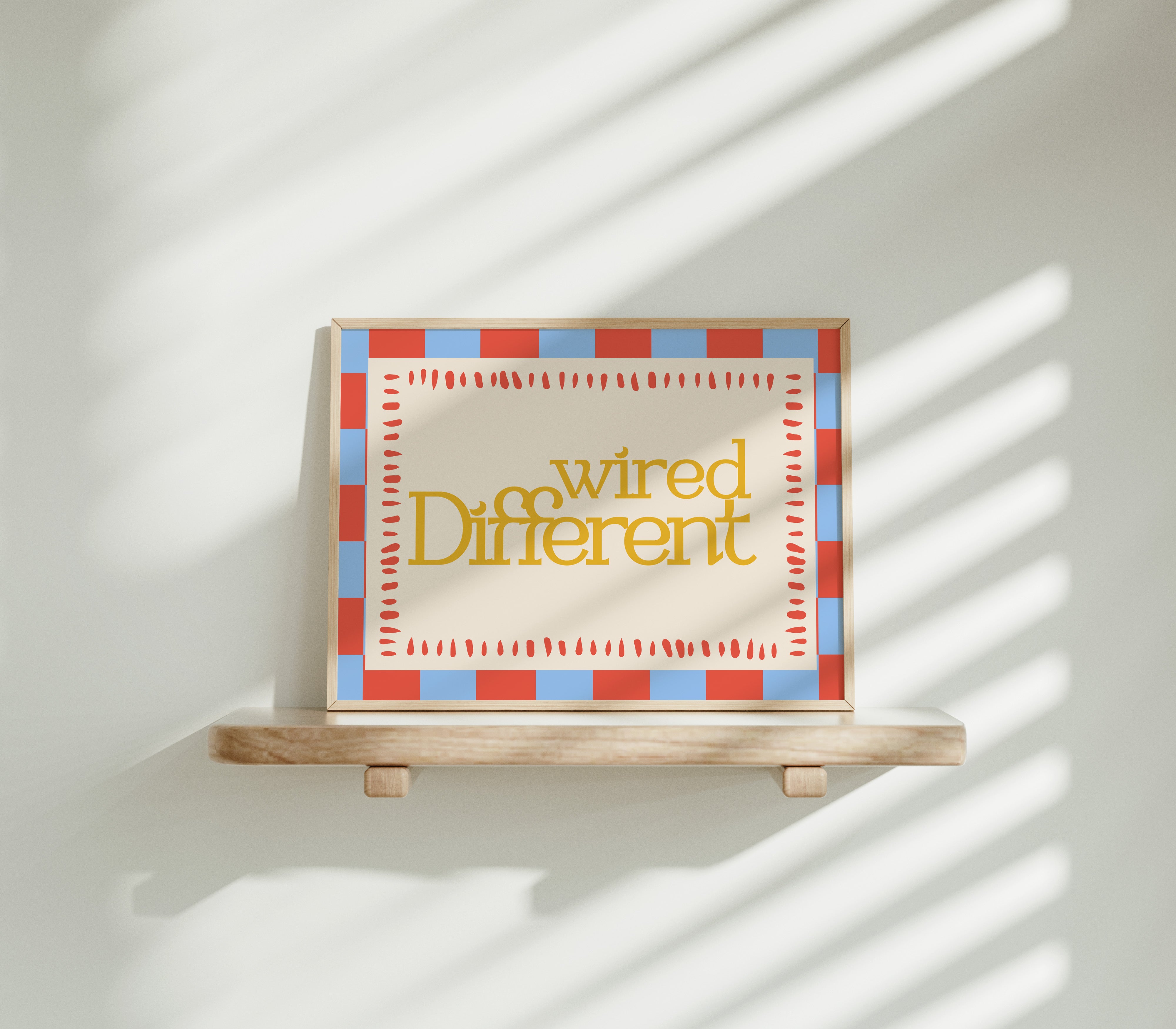 Wired Different horizontal 24x36 mental health wall art poster displayed on a wooden shelf against a sunlit white wall